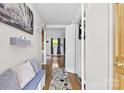 Inviting hallway with a wooden floor, featuring a comfortable bench with decorative pillows and a patterned rug at 1308 Gaston Way, Dallas, NC 28034