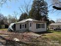 A view of a damaged one-story home with light siding covered with a tarp, awaiting restoration at 1407 Birch St, Kannapolis, NC 28081