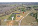 Expansive aerial view of a home's location on a sprawling, partially wooded lot, complete with a tranquil pond at 154 Carters Farm Dr, Statesville, NC 28625