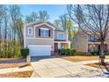 Two-story home featuring an attached garage, inviting front porch, and well-maintained landscaping at 1929 Shorthorn St, Charlotte, NC 28213
