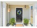 A close-up shot of the front door, adorned with a floral wreath and flanked by lush green plants at 2027 Redstone Dr, York, SC 29745