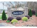 Landscaped entrance to Meadow Creek neighborhood shows stone sign, colorful plantings at 222 Baldwin Ct, Rock Hill, SC 29730