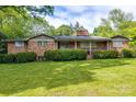 Classic brick home featuring a well-maintained lawn and trimmed hedges in a peaceful, suburban setting at 3330 Foxcroft Rd, Charlotte, NC 28211
