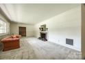 Spacious living room with neutral walls, classic fireplace, and large window for plenty of natural light at 3330 Foxcroft Rd, Charlotte, NC 28211