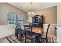 Formal dining room showcases a wooden table, elegant hutch, and natural light from the window at 4026 Clover Nw Rd, Concord, NC 28027