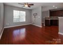 Spacious living room with hardwood floors, a ceiling fan, and a large window at 4548 Antelope Ln, Charlotte, NC 28269