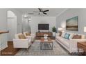 Bright living room with neutral tones, hardwood floors, and a ceiling fan, staged for a cozy and inviting atmosphere at 4554 Craigmoss Ln, Charlotte, NC 28278