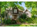 Charming two-story brick home featuring a landscaped front yard and a welcoming entrance framed by mature trees at 4599 Rustling Woods Dr, Denver, NC 28037
