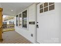 Inviting front porch with wood flooring, freshly painted white siding, and natural wood trim at 530 S Trenton St, Gastonia, NC 28052
