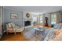 Elegant living room featuring a fireplace, hardwood floors, and sun-filled windows at 5510 Sardis Rd, Charlotte, NC 28270