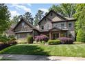 Stone two-story home featuring manicured landscaping and a covered front porch at 5706 Sardis Hall Ct, Charlotte, NC 28270