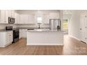 Bright kitchen features white cabinets, granite countertops, stainless steel appliances, and a spacious island at 7110 Jerimoth Dr, Charlotte, NC 28215