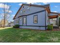Side view of a two-story home featuring blue siding, classic black window trim, and lush green landscaping at 126 E Henderson St, Salisbury, NC 28144
