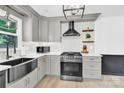 Modern kitchen with stainless steel appliances, quartz countertops, and gray cabinetry at 1308 Spring Lake Dr, Gastonia, NC 28054