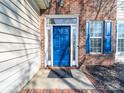 Attractive blue front door surrounded by brick, sidelights and decorative trim with a porch mat at 14802 Rolling Sky Dr, Charlotte, NC 28273