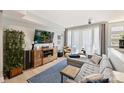 Modern living room with a stylish gray sofa, wooden entertainment center, and access to a balcony at 1651 Duckworth Ave, Charlotte, NC 28208
