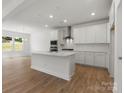 Modern kitchen features white cabinets, stainless steel appliances, and a large center island perfect for entertaining at 2022 Puddle Pond Rd, Indian Trail, NC 28079