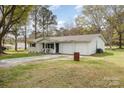 Single-story home with a two-car garage, comfortable front porch sitting area, and spacious yard at 217 Cedarhurst Ln, Clover, SC 29710