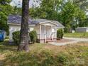 A quaint home featuring mature trees and a covered entryway at 2300 Kennesaw Dr, Charlotte, NC 28216