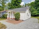 Charming house features a neatly maintained yard with a gravel driveway at 2300 Kennesaw Dr, Charlotte, NC 28216