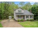 View of the home showing the driveway, siding, and a storage building on a landscaped lot at 2717 Stockwood Dr, Gastonia, NC 28056