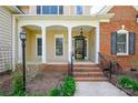 Inviting covered front porch with classic columns, brick steps and railing leading to the front door at 2740 Cameron Commons Way, Matthews, NC 28104