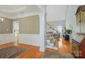 Open living room featuring hardwood floors, staircase, and wainscoting, creating a welcoming space at 2740 Cameron Commons Way, Matthews, NC 28104