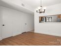 Dining room area with hardwood floors, hanging light fixture, and opening to the kitchen at 3709 Willow Point Dr, Charlotte, NC 28277
