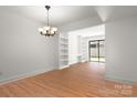 A spacious living room with hardwood floors, modern lighting, and built in shelving at 3709 Willow Point Dr, Charlotte, NC 28277