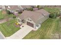 An elevated view of a well-maintained property featuring green lawn, a brown roof and driveway and landscaping at 423 Granite Lake Ct, Denver, NC 28037