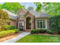 Charming brick home showcasing a well-kept lawn and an elegant arched doorway at 4646 Eagle Pointe Ct, Denver, NC 28037