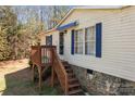 Exterior angle view of the home's entrance and porch with white siding and blue trim at 4793 Appaloosa Ln, Maiden, NC 28650