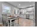 Bright kitchen features white cabinets, stainless steel appliances, and dining area at 501 S Inman Ave, Bessemer City, NC 28016