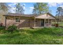 A classic brick home featuring a covered porch, with a quaint and inviting front yard and carport at 518 W Westview St, Gastonia, NC 28052