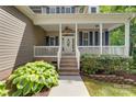 Charming home featuring a covered porch, brick steps, and mature landscaping, creating inviting curb appeal at 6414 Winding Creek Ln, Denver, NC 28037