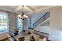 Well-appointed dining room showcasing coffered ceilings, stylish curtains, and a view of the staircase at 7016 Butternut Oak Ter, Huntersville, NC 28214