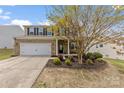 Charming two-story brick home with a well-manicured lawn and attached two-car garage at 10773 Sapphire Trl, Davidson, NC 28036
