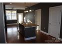 Spacious kitchen island with sink and pendant lighting, complemented by hardwood floors and neutral decor at 121 Irving Ave # A, Mooresville, NC 28117
