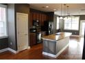 Modern kitchen featuring dark wood cabinets, granite countertops, stainless steel appliances, and center island at 121 Irving Ave # A, Mooresville, NC 28117
