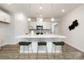 Bright kitchen features white cabinets, stone backsplash, stainless appliances, and a large center island at 124 N Shayna Rd, Troutman, NC 28166
