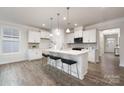 Bright kitchen features white cabinets, stone backsplash, stainless appliances, and a large center island at 124 N Shayna Rd, Troutman, NC 28166