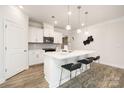 Bright kitchen features white cabinets, stone backsplash, stainless appliances, and a large center island at 124 N Shayna Rd, Troutman, NC 28166