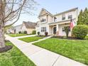 Traditional-style home with a neatly landscaped front yard, sidewalk and an inviting facade at 14923 Colonial Park Dr, Huntersville, NC 28078