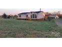 A charming one-story home with a well-kept lawn, wooden porch, and a utility shed on the property at 1524 J Rhyne Reep Rd, Vale, NC 28168
