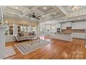 Open-concept living room featuring hardwood floors, a fireplace and a coffered ceiling at 16123 Chiltern Ln, Huntersville, NC 28078