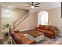Inviting living room features two brown couches, wood floors, ceiling fan, and a staircase at 165 Singleton Rd, Mooresville, NC 28117