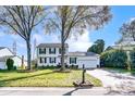Traditional two-story home with white siding, black shutters, and a well-manicured front lawn with mature trees at 2243 Flint Glenn Ln, Charlotte, NC 28262