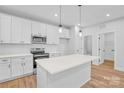 Modern kitchen featuring stainless steel appliances, white cabinets, and a central island at 405 Sullivan Ave, Gastonia, NC 28052