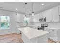 Bright kitchen with white cabinetry, stainless appliances, a subway tile backsplash, and large island at 405 Sullivan Ave, Gastonia, NC 28052