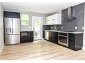Contemporary kitchen featuring stainless steel appliances, black-and-white cabinetry, ample countertop space, and natural light at 411 Cemetery St, Charlotte, NC 28216